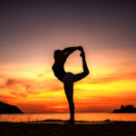 Silhouette sport woman graceful yoga pose Dancer Pose (Natarajasana) against the glowing perfectly represents the essence of meditation, wellness and the pursuit of balance in life.